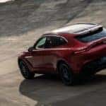 Red Aston Martin DBX driving on outdoor track