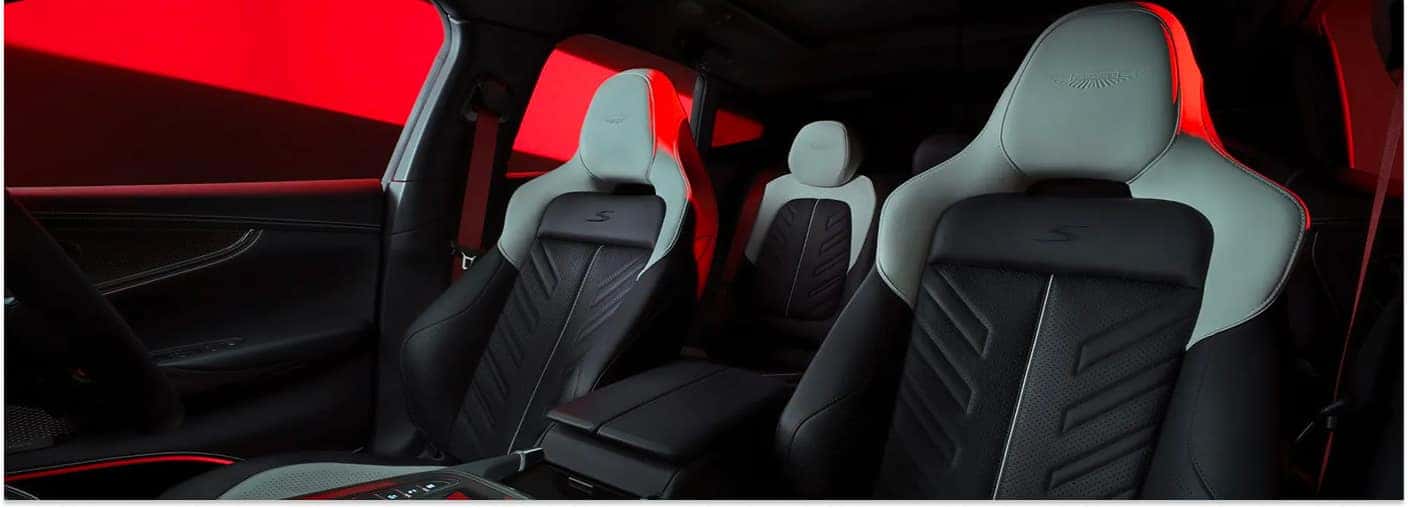 Interior view of a 2026 Aston Martin DBX featuring two-tone black and light gray leather seats with red accents.
