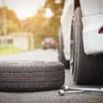 Image of a car with a spare tire being replaced