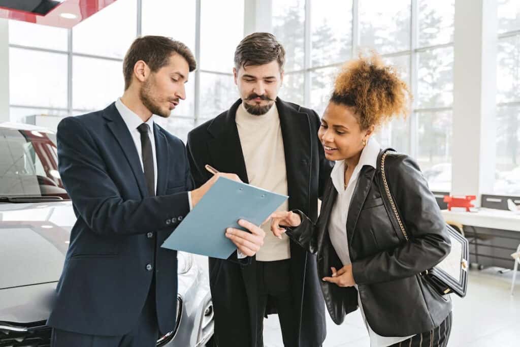 Sales associate showing deals to a car buyer in a showroom
