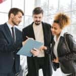 Sales associate showing deals to a car buyer in a showroom