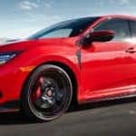 One of the new Hondas for sale in Duluth, GA, a red 2021 Honda Civic Type R is shown driving on a street.