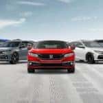 Five different 2020 Honda Civic models are parked in front of distant mountains.