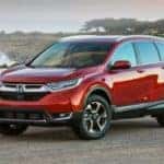 A red 2019 used Honda CR-V is parked in front of the ocean.