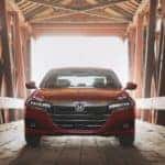 A red 2021 Honda Accord is shown driving through a covered bridge after leaving an Atlanta Honda Accord dealer.