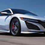 A white used 2020 Acura NSX is shown driving from a low angle after leaving a Atlanta used luxury car dealership.