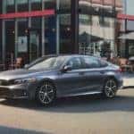 A grey 2022 Honda Civic Touring is shown parked outside a coffee shop.