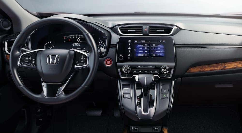 The interior of a 2020 CR-V Hybrid shows the steering wheel and infotainment screen.