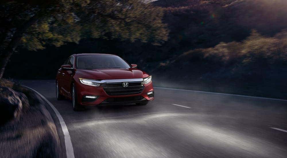 A red 2020 Honda Insight Touring is shown driving at dusk.