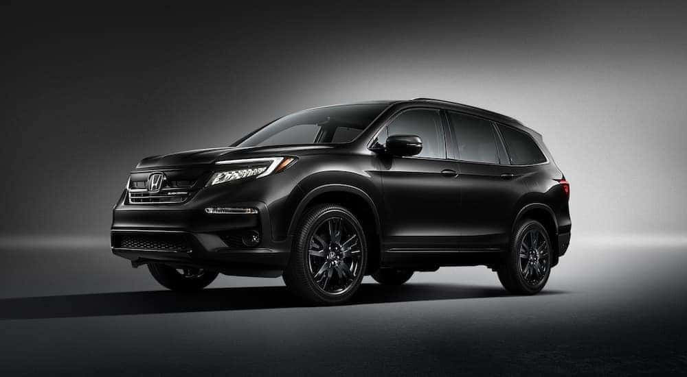 A black 2021 Honda Pilot Black Edition is shown against a dark background.