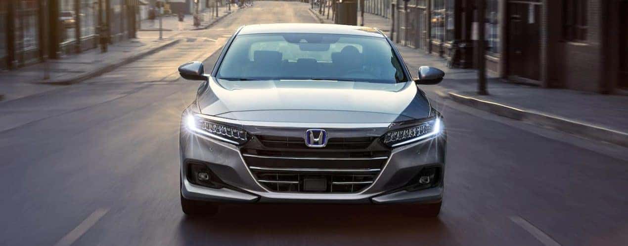 A silver 2022 Honda Accord Hybrid Touring is shown from the front on a city street.