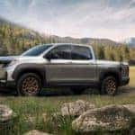 A silver 2022 Honda Ridgeline HPD is shown from the side on a dirt trail after leaving a off-road truck dealer.