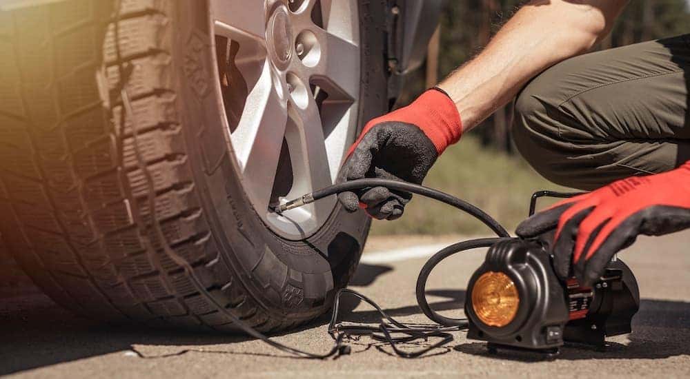 A small air compressor is shown adding air to a tire.