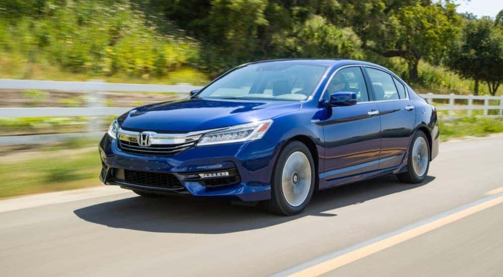 A blue 2017 Honda Accord is shown from the front at an angle while driving down the highway.