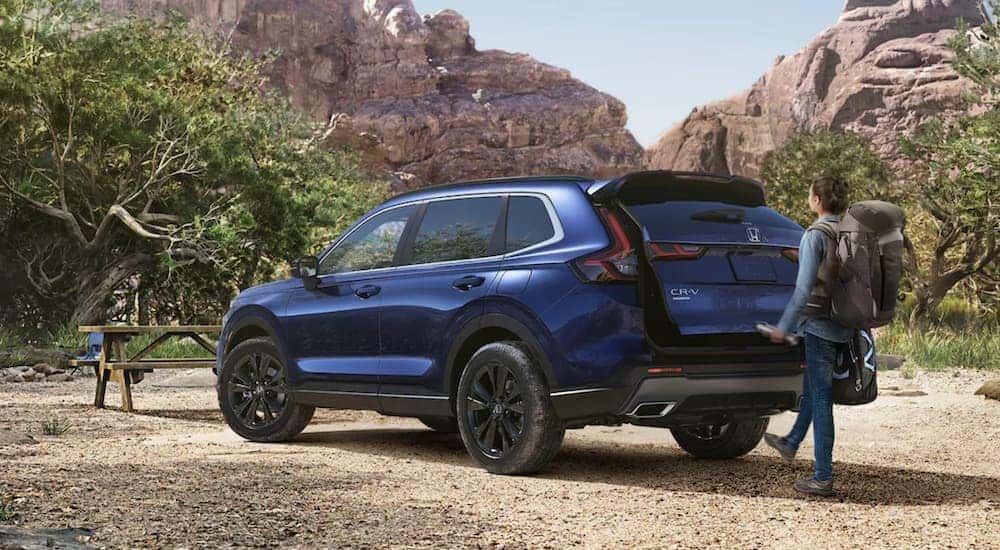 A popular Honda CR-V for sale, a blue 2023 Honda CR-V Sport Touring Hybrid, is shown parked in the desert.
