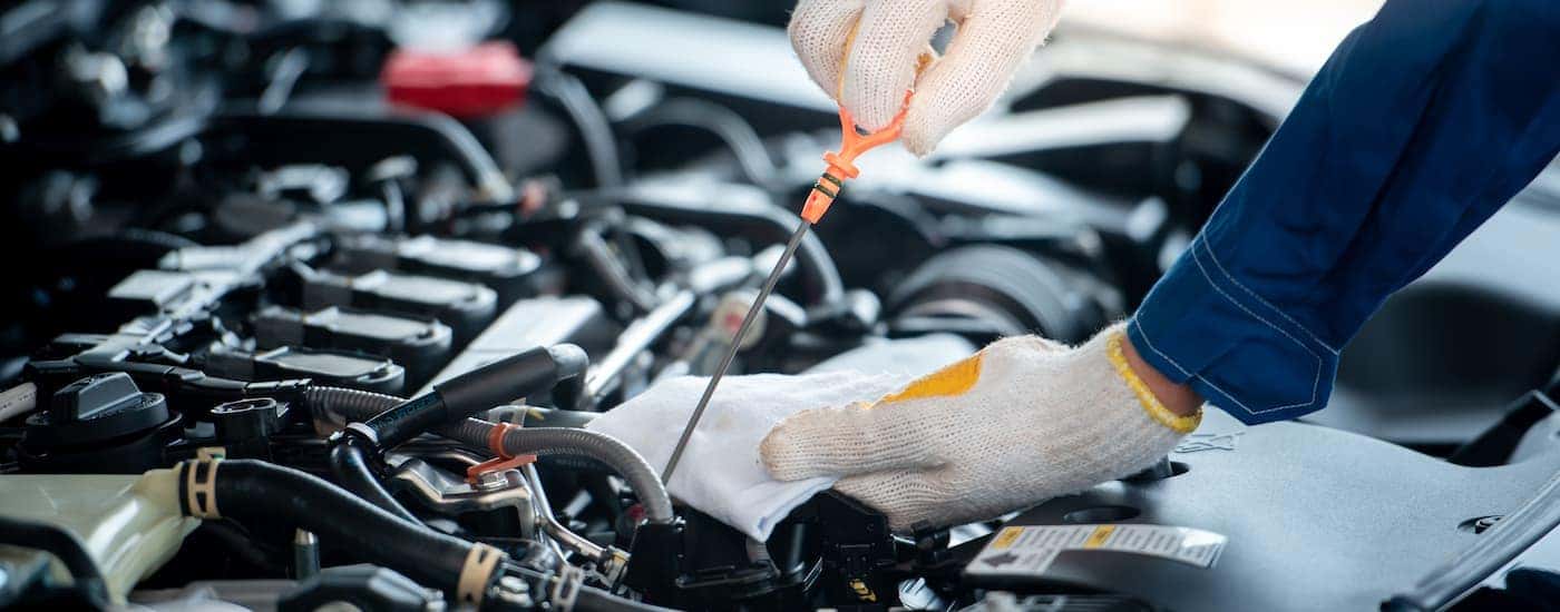 A mechanic is shown inspecting the oil levels of an engine.