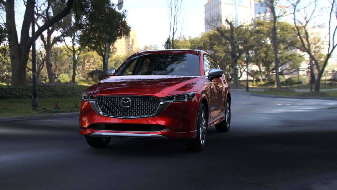 Red CX-5 driving in the city. 