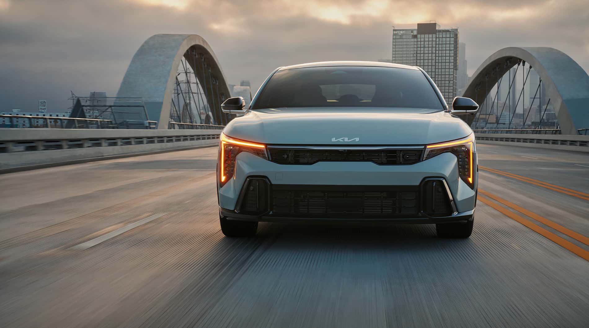 Kia K4 parked on a bridge.