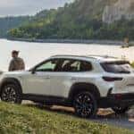 MAZDA CX-50 Hybrid overlooking a lake with a person on the hood.