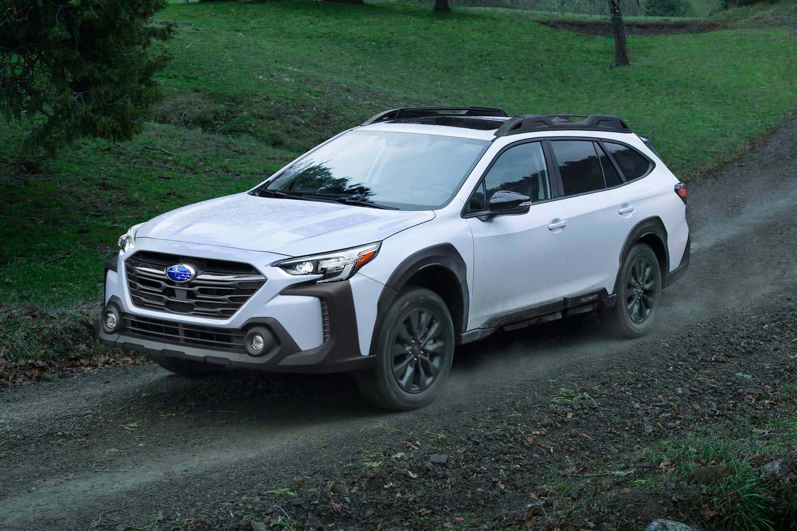 2025 Subaru Outback driving on a dirt road.