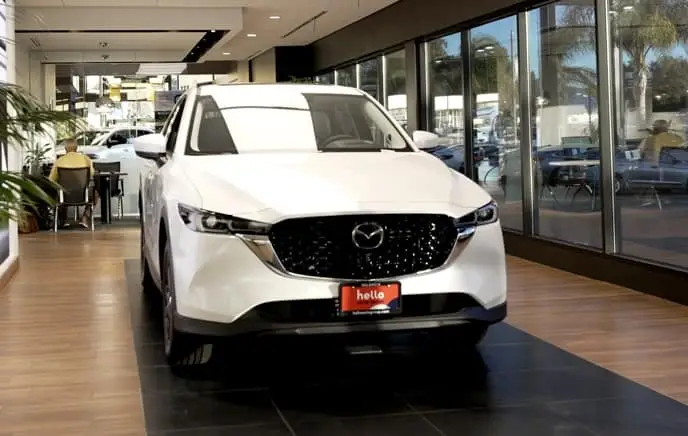 A red Mazda sedan is turning city corner