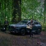 2025 Mazda CX-50 off road in a forest with camper.