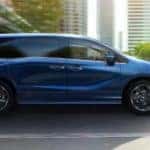 A blue 2021 Honda Odyssey Elite is shown from the side on a city street near Newnan, GA.