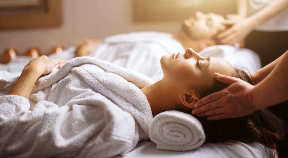A man and woman in white robes enjoying a spa day after visiting their local Honda dealer