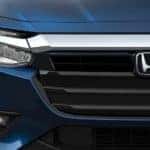 A closeup shows the grille and a headlight on a blue 2021 Honda Insight Touring.