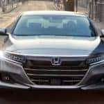 A silver 2021 Honda Accord is shown from the front driving down the street after leaving an Atlanta Honda Accord dealership.