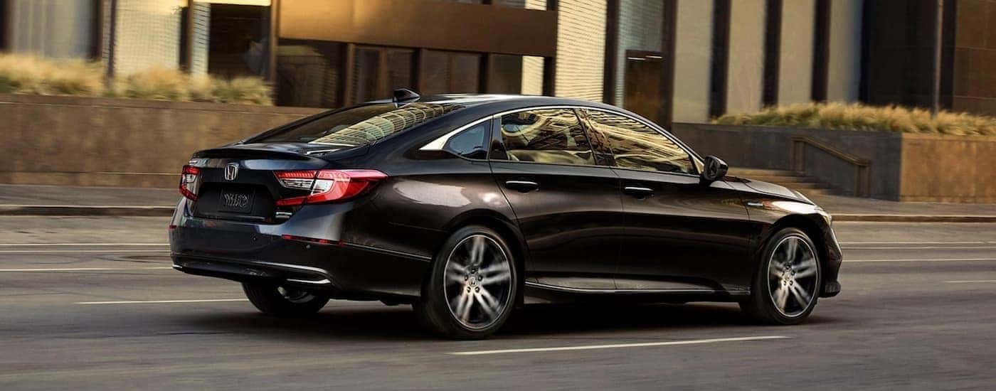 Side view of a black 2021 Honda Accord Hybrid driving through a city after leaving a Atlanta Honda Accord dealership