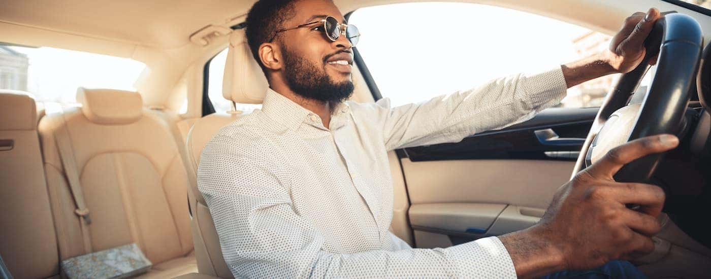 Man in sunglasses test driving a car at a Honda dealer in Atlanta