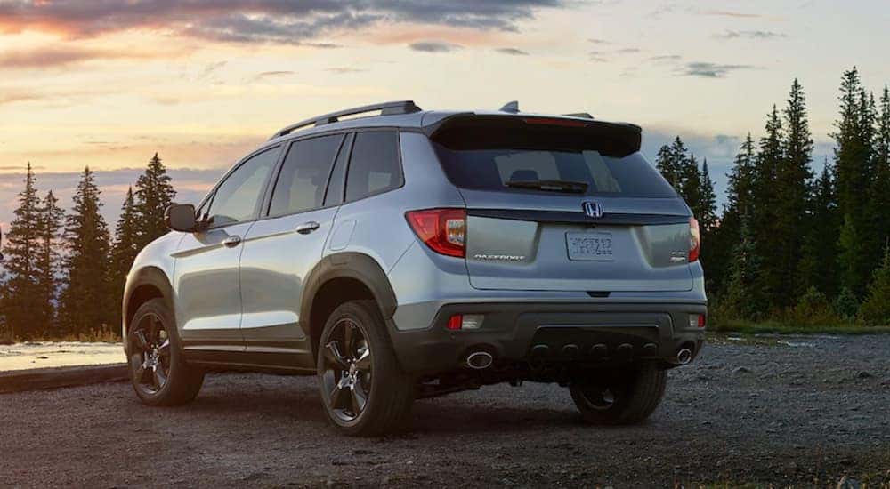 Rear view of a blue 2021 Honda Passport Elite parked by a pond after leaving a GA Honda Passport dealer