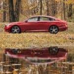 A red 2021 Honda Accord Touring 2.0T is shown from the side parked in front of a pond.