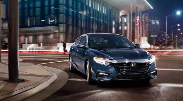 A blue 2022 Honda Insight Touring is shown leaving a Peachtree City Honda dealership.