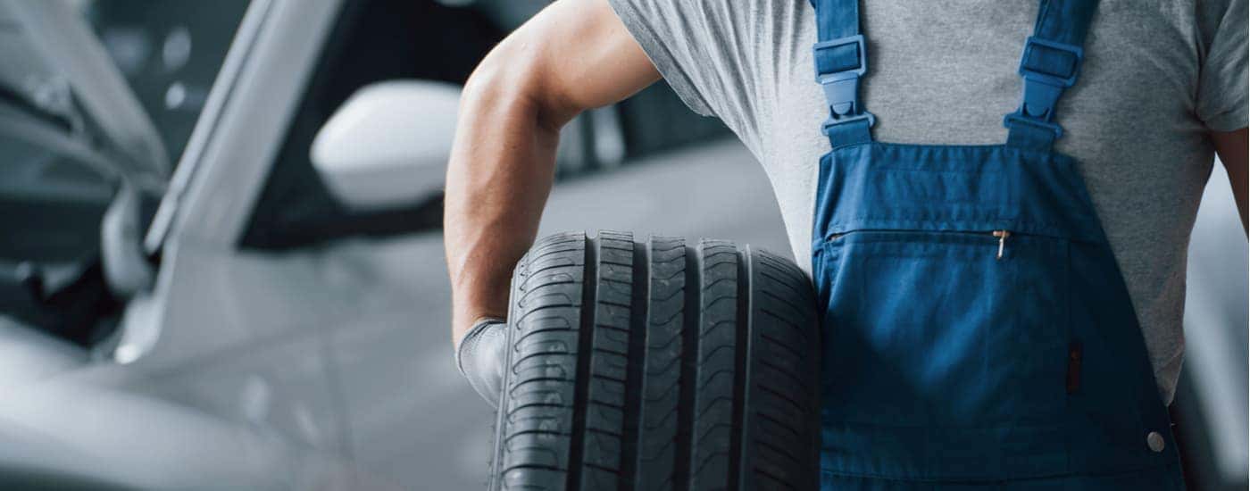 A mechanic is shown holding a tire at a Senoia Honda dealer.