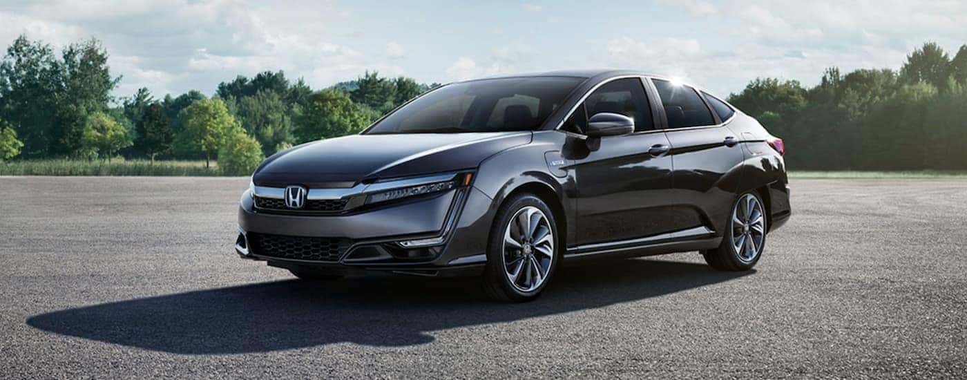 A grey 2021 Honda Clairty Plug-In is shown from the side on pavement.