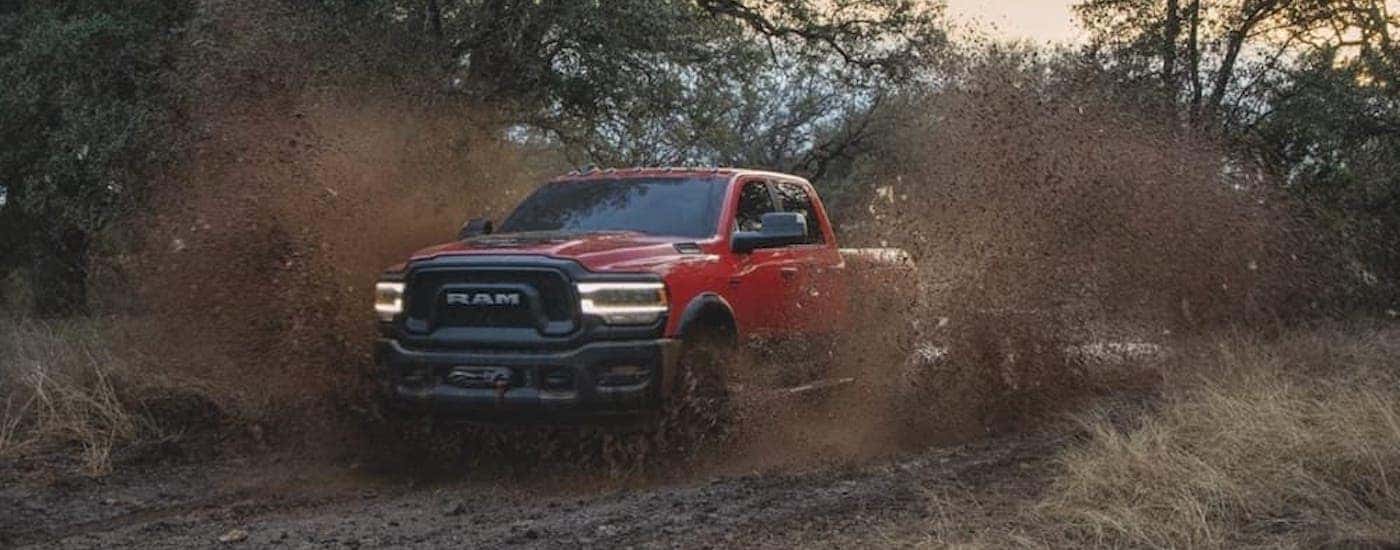Front view of a red 2021 Ram 2500 Power Wagon driving through mud after the owner searched 'used trucks for sale'