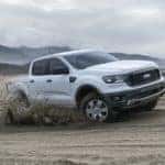 A white 2019 Ford Ranger is shown driving on a beach.