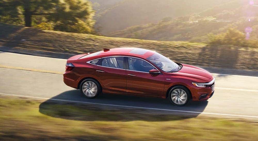 A red 2022 Honda Insight is shown from the side after leaving a Fayetteville Honda dealership.