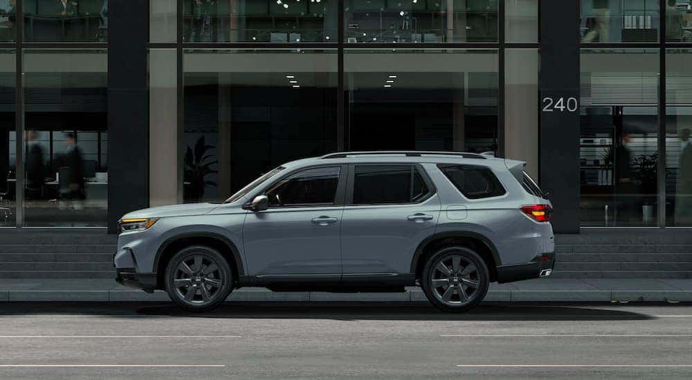A grey 2023 Honda Pilot for sale near Carrollton is shown in front of a buidling.