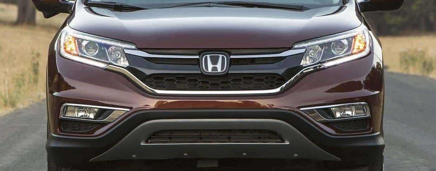 A popular Honda CR-V For sale, a brown 2016 Honda CR-V, is shown from the front parked on a road.