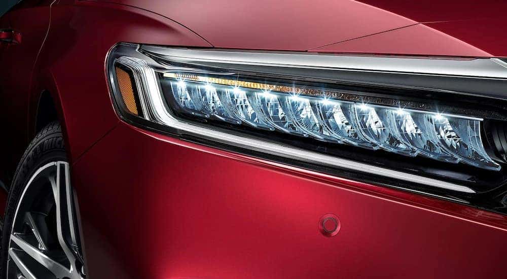 A close up of the headlight on a red 2022 Honda Accord Touring is shown.