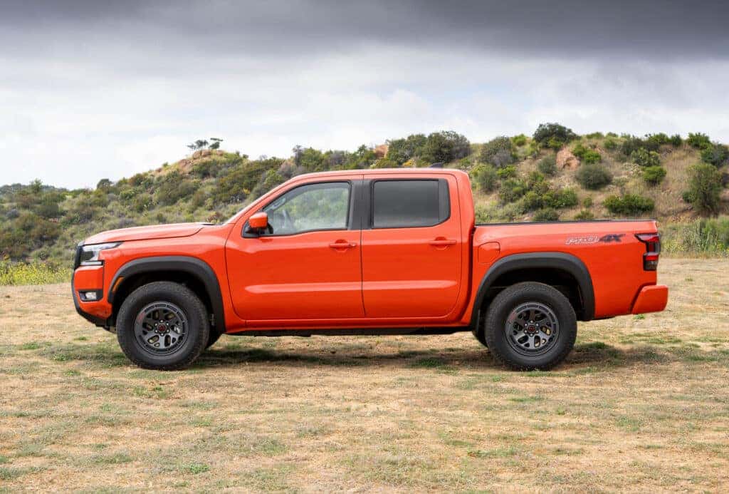 2026 Nissan Frontier PRO-4X In an open field, interior is a bright orange