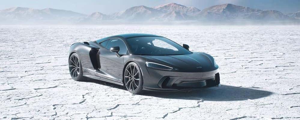 Silver McLaren GTS driving on mountain highway