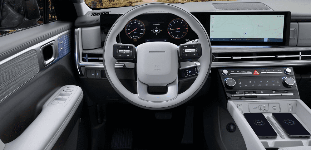 Interior of the 2026 Hyundai Santa Fe featuring a modern steering wheel, digital display, and infotainment system.