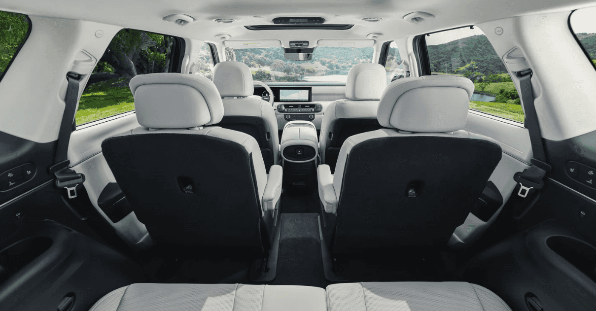 Spacious interior of the 2026 Hyundai Palisade featuring two-tone upholstery, captain’s chairs, and a touchscreen display up front.