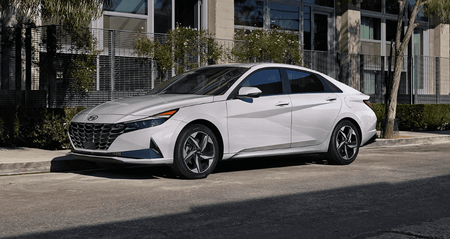 White 2026 Hyundai Elantra Hybrid parked outside of residential apartments.
