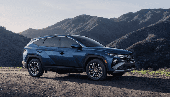 Blue 2026 Hyundai Tucson Hybrid parked on hill.