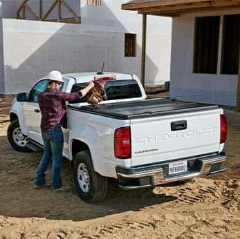 Basic Car Maintenance and Servicing Checklist | Performance Chevrolet | Construction worker gets bag of tools from Colorado's bed